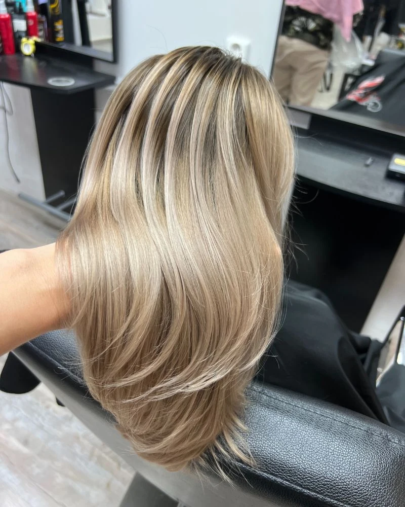 Blond melír s plynulým přechodem od tmavších kořínků, pohled zezadu.