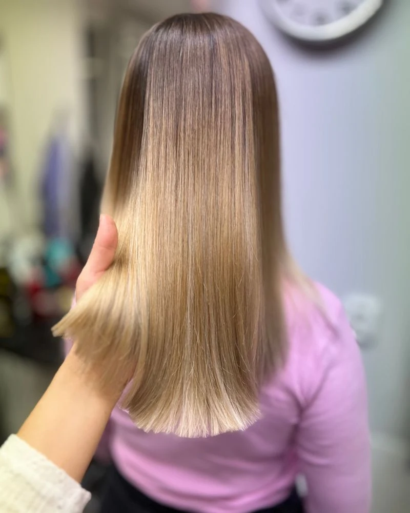 Rovný blond účes s postupným zesvětlením délek.