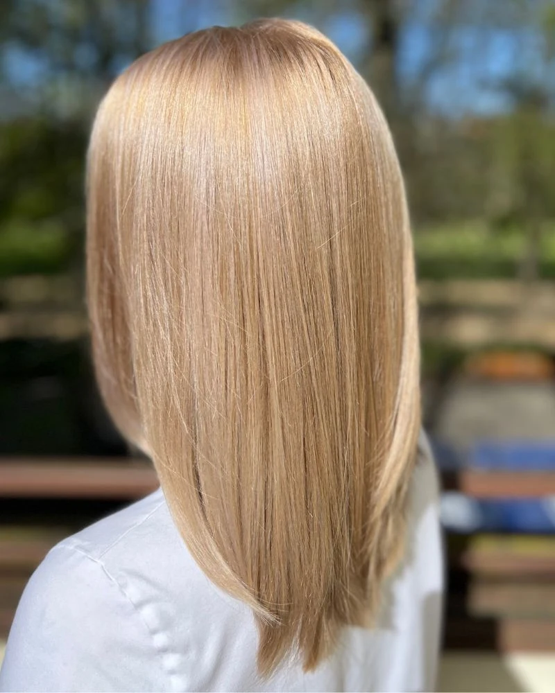 Krátký blond střih s hladkou úpravou, pohled zezadu.